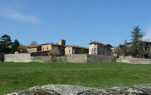 Entrée Sud de Savigny, on aperçoit une partie des murs d'enceinte de l'abbaye ainsi que la tour de l'horloge