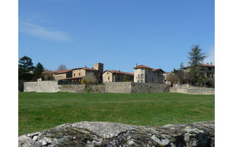 Entrée Sud de Savigny, on aperçoit une partie des murs d'enceinte de l'abbaye ainsi que la tour de l'horloge